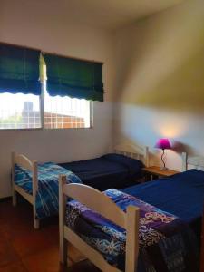 1 dormitorio con 2 camas y ventana en Casa rural, en Nueva Palmira