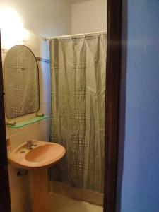 y baño con cortina de ducha y lavamanos. en Casa rural, en Nueva Palmira
