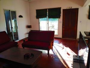 Sala de estar con sofá rojo y mesa de centro en Casa rural, en Nueva Palmira