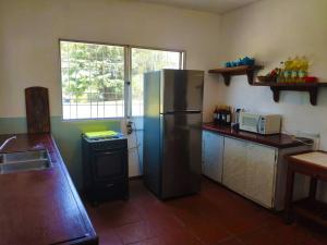 a kitchen with a stainless steel refrigerator and a window at Casa rural in Nueva Palmira