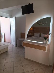 a bedroom with a bed and a tv on the wall at Filomeni Studios in Pefkohori