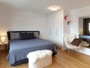 オーバーシュタウフェンにあるFEWO Monaのベッドルーム(青いベッド1台、椅子付)