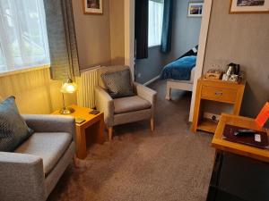 een woonkamer met een bank en een stoel bij Brookside Guest House & Mini Spa in Brixham