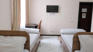 a hospital room with two beds and a tv at Apple Hostel Bishkek in Bishkek