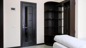 a bedroom with a black book shelf next to a bed at Apple Hostel Bishkek in Bishkek