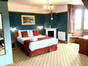 a bedroom with a large bed and a fireplace at Purbeck House Hotel & Louisa Lodge in Swanage