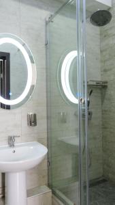 a bathroom with a sink and a glass shower at Apple Hostel Bishkek in Bishkek