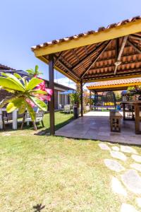 eine Terrasse mit einer hölzernen Pergola und einem Tisch in der Unterkunft Pousada Kanamary in Praia do Frances