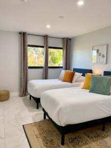 2 camas en una habitación con 2 ventanas en El Dorado Pool House, en Cabo Coral