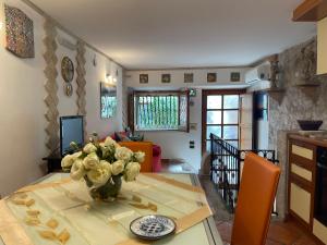 a dining room table with a vase of flowers on it at Majolica Taormina Apartment in Taormina