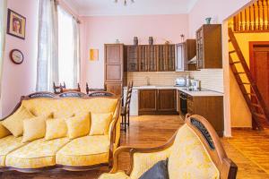 a living room with a couch and a kitchen at Astronomical Clock Suite by Ruterra in Prague +13 photos