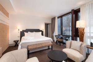 una camera d'albergo con letto, tavolo e sedie di Hotel Villa Carona a Carona