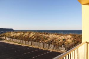 a balcony with a fence and the ocean in the background at Surf Side Hotel in Nags Head