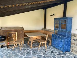 Pokój ze stołem i krzesłami oraz niebieską szafką w obiekcie Kégli apartmanok és fürdőház Hollókő w mieście Hollókő