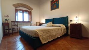 Un dormitorio con una cama grande y una ventana en Dietro Le Mura, en Colle Val D'Elsa