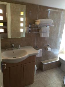 a bathroom with a sink and a toilet and a mirror at Roseneath Guest House in Inverness