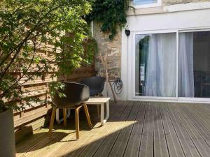 a patio with two chairs and a table and a window at L'Oxalis villa (Le Cocon) in Bullion