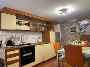 a kitchen with white cabinets and a table with a dining room at Majolica Taormina Apartment in Taormina +7 photos