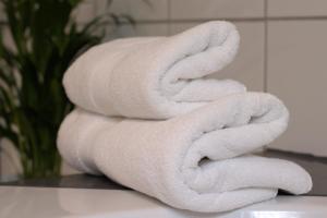 una pila de toallas blancas sentadas en la encimera del baño en Idyllisches Wohnen in grüner Oase, en Griesheim