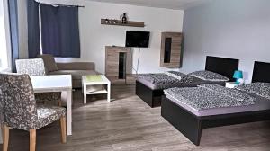 uma sala de estar com duas camas e um sofá em Aparthotel DKS em Chomutov