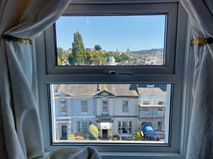 ein Fenster mit Blick auf ein Gebäude in der Unterkunft The Norwood in Torquay