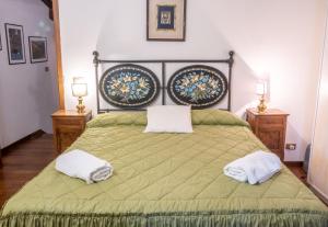 a bedroom with a green bed with two towels on it at Dimora Iguvium in Gubbio