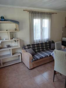 salon z kanapą i oknem w obiekcie Marie-Angela HOUSE ARILLAS w Korfu
