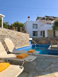Villa con piscina y 2 tumbonas en Mourtzanakis Residence - Traditional Eco Hotel in Achlada en Achlada