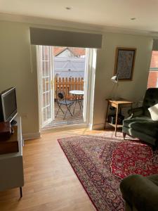 a living room with a couch and a television and a table at The Garden House in Bishop Burton