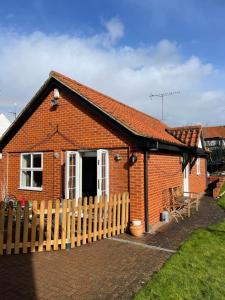 a small red brick house with a wooden fence at The Garden House 