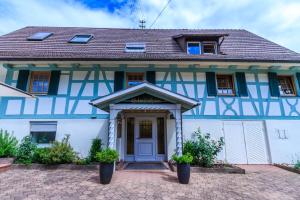 una casa azul y blanca con una puerta principal en Hirschen Apartments, en Oberreute