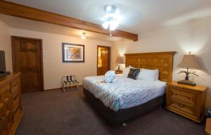 a bedroom with a bed and a dresser and a television at Heather Lodge in Minden