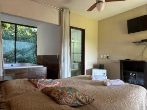 a bedroom with a bed and a tub and a window at Macaco Prosa in Macacos
