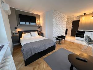 ein Hotelzimmer mit einem Bett, einem Schreibtisch und einem Zimmer in der Unterkunft Panorama Studio At Sky in Warschau