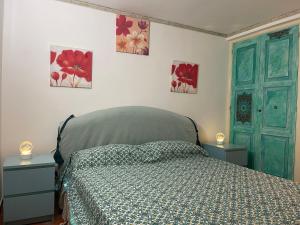 a bedroom with a bed and three paintings on the wall at Majolica Taormina Apartment in Taormina