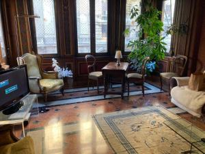 a living room with chairs and a table and a tv at Le Stanze del Notaio in Genoa