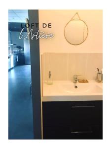 a bathroom with a sink and a mirror on the wall at Loft de l'Artière 75 m2 - Vue Chaîne des Puys in Romagnat
