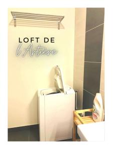a bathroom with a toilet and a sign on the wall at Loft de l'Artière 75 m2 - Vue Chaîne des Puys in Romagnat