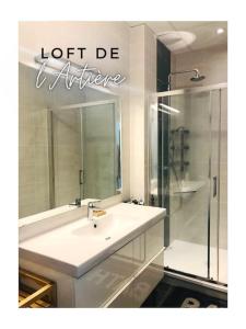La salle de bains est pourvue d'un lavabo et d'une douche avec un miroir. dans l'établissement Loft de l'Artière 75 m2 - Vue Chaîne des Puys, à Romagnat