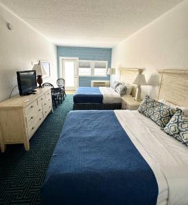 a hotel room with two beds and a television at Surf Side Hotel in Nags Head