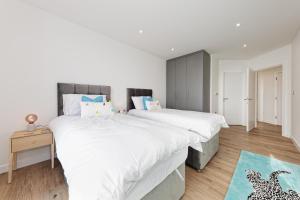 1 dormitorio con 2 camas y alfombra azul en Beach Front 2Bed Sea View & Parking, en Ramsgate