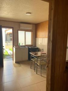 a kitchen with a table and chairs and a kitchen with a sink at Cabañas Bosque Sur in Puerto Varas