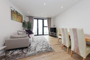 Una sala de estar con un sofá y una mesa de comedor. en Beach Front 2Bed Sea View & Parking, en Ramsgate
