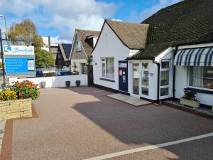 a house with a driveway in front of a building at Brookside Guest House & Mini Spa in Brixham