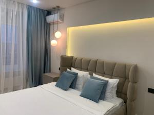 a bedroom with a bed with blue and white pillows at Dream Apartment in Bila Tserkva
