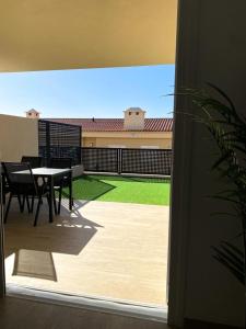 Elle offre une vue sur une terrasse avec une table et de la pelouse. dans l'établissement Playa Negra Holiday, à Puerto de Santiago