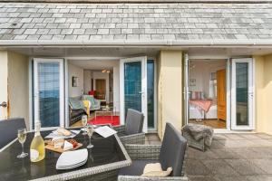 a patio with a table and chairs and a house at 3 At The Beach, Torcross in Beesands