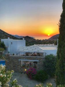 a house with a sunset in the background at Mourtzanakis Residence - Traditional Eco Hotel in Achlada in Achlada