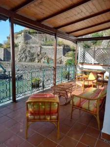 a patio with chairs and tables on a balcony at Villa la caletta in Maiori
