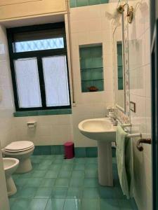 La salle de bains est pourvue d'un lavabo, de toilettes et d'une fenêtre. dans l'établissement Villa la caletta, à Maiori